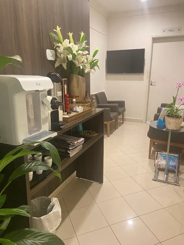 Sala de espera da Saab Odontologia com poltronas, televisão e mesa de café